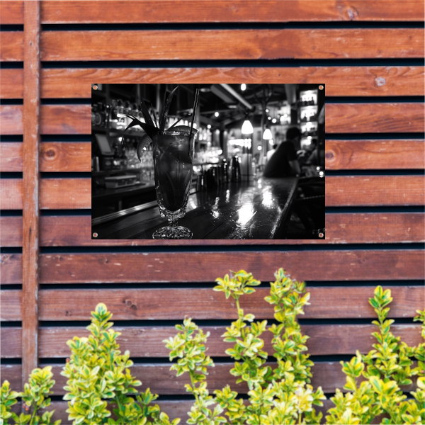 Zwart-wit cocktailglas op houten bar tuinposter