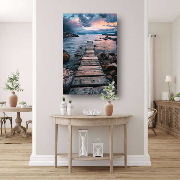 Oude houten steiger leidt naar kalme zee bij zonsondergang poster