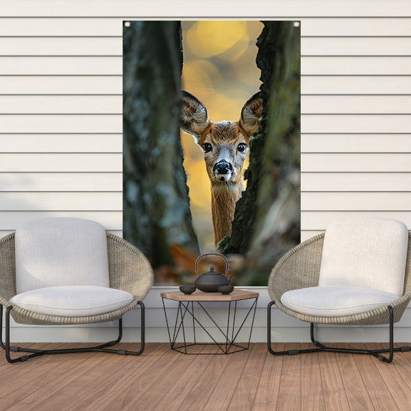 Jonge hert kijkt tussen bomen in herfstbos tuinposter