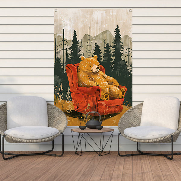 Bruine beer in rode fauteuil in bos tuinposter