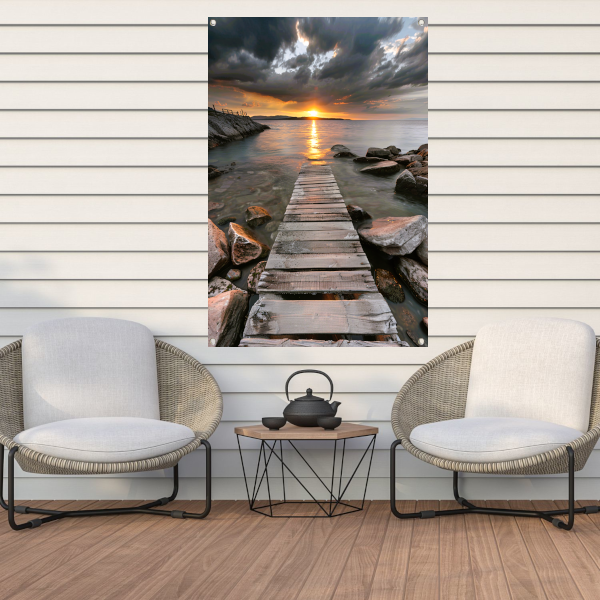 Gouden zonsondergang met dramatische wolken en steiger tuinposter