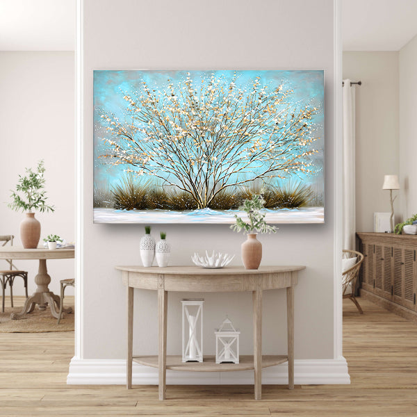 Sierlijke boom met sneeuw tegen blauwe lucht canvas